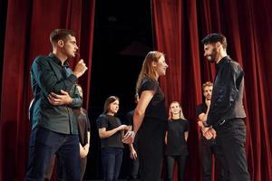 Due persone parlando. gruppo di attori nel buio colorato Abiti su prova nel il Teatro foto