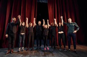 persone inchinandosi per pubblico. gruppo di attori nel buio colorato Abiti su prova nel il Teatro foto