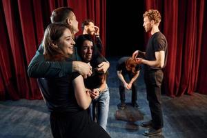 Lavorando insieme. gruppo di attori nel buio colorato Abiti su prova nel il Teatro foto