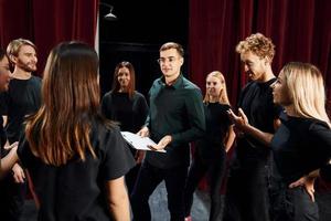 gruppo di attori nel buio colorato Abiti su prova nel il Teatro foto