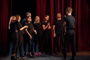 gruppo di attori nel buio colorato Abiti su prova nel il Teatro foto