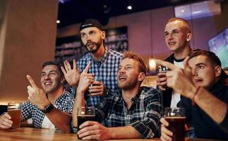 calcio fan Guardando tv. gruppo di persone insieme in casa nel il pub avere divertimento a fine settimana tempo foto