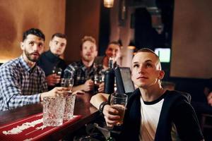 espressive persone Guardando calcio. gruppo di persone insieme in casa nel il pub avere divertimento a fine settimana tempo foto