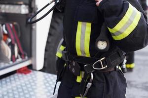 femmina pompiere nel protettivo uniforme in piedi vicino camion foto