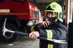 maschio pompiere nel protettivo uniforme in piedi vicino camion foto