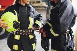 maschio e femmina i vigili del fuoco nel protettivo uniforme in piedi insieme foto