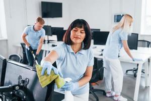 pulisce tenere sotto controllo. gruppo di lavoratori pulito moderno ufficio insieme a giorno foto