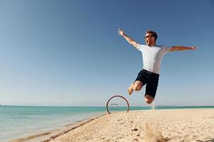 avendo divertimento. giovane europeo uomo avere vacanza e godendo gratuito tempo su il spiaggia di mare foto