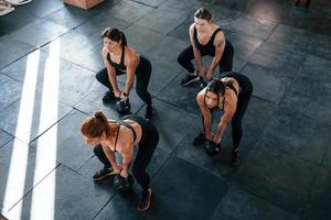 sollevamento di pesante pesi. gruppo di giovane allegro persone avere CrossFit giorno in casa nel Palestra foto