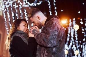 contento multirazziale coppia insieme all'aperto nel il città festeggiare nuovo anno foto