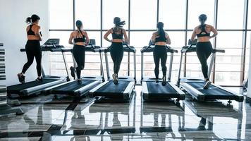 in esecuzione su un' tapis roulant. gruppo di giovane allegro persone avere CrossFit giorno in casa nel Palestra foto