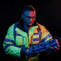 poliziotto con bomba. futuristico neon illuminazione. giovane africano americano uomo nel il studio foto