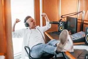 parla e usi microfono. giovane uomo è in casa nel il Radio studio è occupato di trasmissione foto