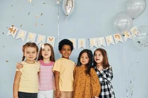 in posa per il telecamera. bambini su festeggiare compleanno festa in casa avere divertimento insieme foto