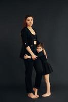 madre e figlia è insieme nel il studio contro nero sfondo foto