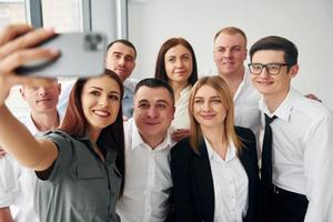 fa autoscatto. gruppo di persone nel ufficiale formale Abiti quello è in casa nel il ufficio foto