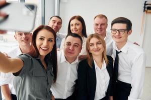 fa autoscatto. gruppo di persone nel ufficiale formale Abiti quello è in casa nel il ufficio foto