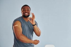 giovane africano americano uomo dopo vaccino iniezione è in casa foto