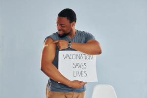 vaccinazione salva vite striscione. giovane africano americano uomo dopo vaccino iniezione foto