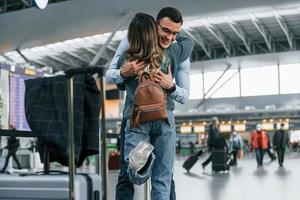 Abbracciare una persona ogni Altro. giovane coppia è nel il aeroporto insieme foto