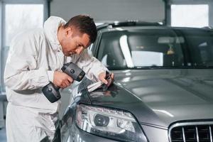 professionale lavoratore. uomo nel uniforme è nel il auto servizio foto