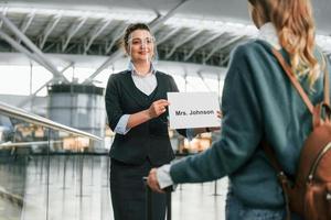 assistenza di donna nel formale Abiti. giovane femmina turista è nel il aeroporto a giorno foto