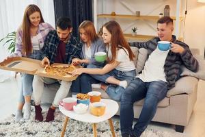 mangiare cibo e potabile tè. gruppo di amici avere festa in casa insieme foto