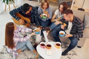 nel domestico camera. gruppo di amici avere festa in casa insieme foto