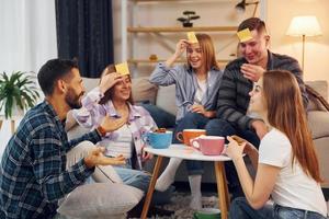 giallo adesivi su fronte. gruppo di amici avere festa in casa insieme foto