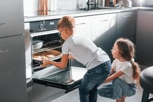 cottura al forno cibo. poco ragazzo e ragazza preparazione Natale biscotti su il cucina foto