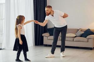 apprendimento per danza. padre con il suo poco figlia è a casa insieme foto