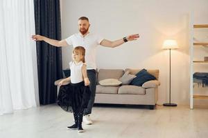 yoga pose. padre con il suo poco figlia è a casa insieme foto