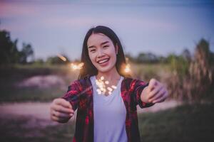 asiatico bella ragazza Tenere ardente sparkler celebrazione nel nuovo anno foto