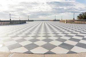 livorno,italia-novembre 27, 2022 persone passeggiando su il mascagni terrazza, un' splendida belvedere terrazza con scacchiera pavimentata superficie, Livorno, Toscana, Italia durante un' soleggiato giorno. foto