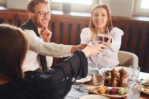 applauso con bicchieri di vino. in casa di nuovo moderno lusso ristorante foto