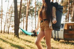 caldo luce del sole. donna è in viaggio solo nel il foresta a giorno a estate foto