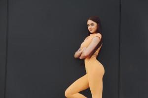 giallo abbigliamento sportivo. giovane donna avere fitness sessione all'aperto foto