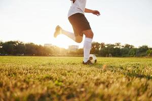 corre con sfera. giovane calcio giocatore avere formazione su il allegro campo foto