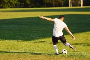 calci il sfera. giovane calcio giocatore avere formazione su il allegro campo foto