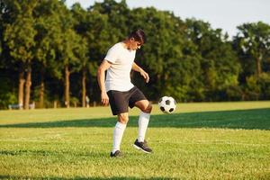 giovane calcio giocatore avere formazione su il allegro campo foto