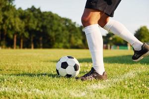 soleggiato giorno. giovane calcio giocatore avere formazione su il allegro campo foto