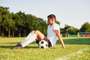 prende un' rompere. giovane calcio giocatore avere formazione su il allegro campo foto