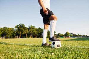 soleggiato giorno. giovane calcio giocatore avere formazione su il allegro campo foto