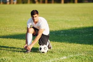 preparazione per il gioco. giovane calcio giocatore avere formazione su il allegro campo foto