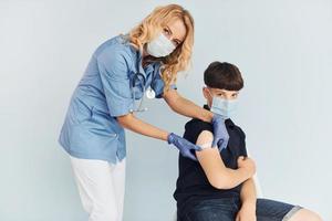 giovane ragazzo. medico nel uniforme fabbricazione vaccinazione per il paziente foto