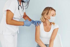 medico nel uniforme fabbricazione vaccinazione per il donna foto