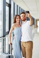 Due le persone. giovane viaggiatore è su il Ingresso sala nel il aeroporto foto