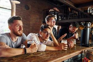 calcio fan. persone nel casuale Abiti seduta nel il pub foto