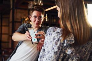 giovane uomo con donna. persone nel casuale Abiti seduta nel il pub foto