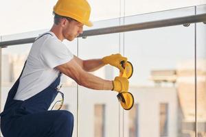 utilizzando attrezzo. giovane uomo Lavorando nel uniforme a costruzione a giorno foto